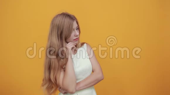 严肃的金发女人把手指放在头上一边纠正头发视频的预览图
