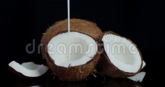 椰子奶慢慢地流淌在半个新鲜的椰子里视频的预览图