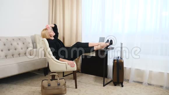 年轻女性工作后在舒适的扶手椅上放松满足所有目标准备好行李休息的双手视频的预览图