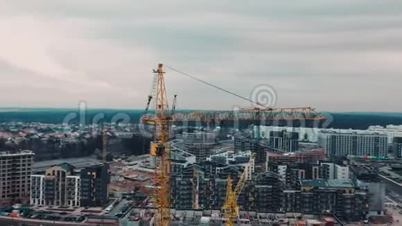 在现代城市大城市的背景下建造强大的起重机无人驾驶飞机靠近建筑起重机视频的预览图