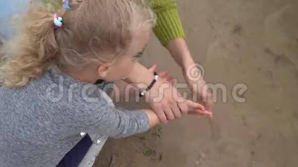 母亲在湖水中给女儿洗手万向节运动视频的预览图