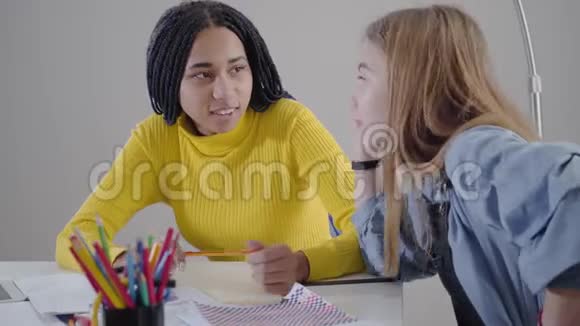 侧面看白种人女孩与她的非裔美国朋友交谈并在情感上做手势朋友聊天视频的预览图
