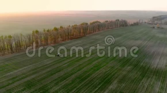 农用拖拉机的鸟瞰图用喷雾器耕种田地视频的预览图