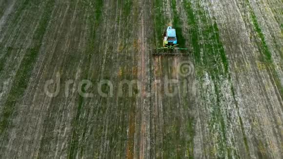 鸟瞰农业拖拉机在日落时犁田4k视频的预览图