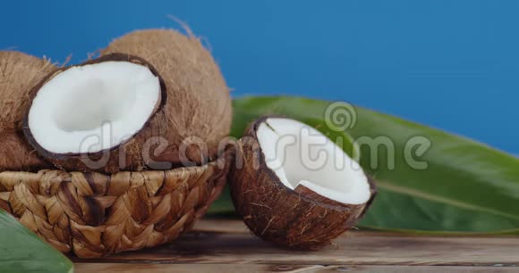 放在木桌上有叶子的篮子里的椰子视频的预览图
