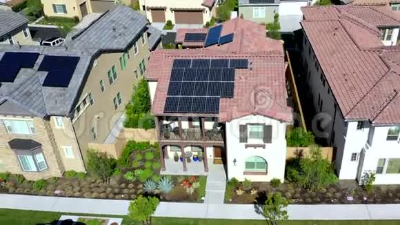 在郊区屋顶社区利用太阳能电池板技术从住宅房屋上方拉回鸟瞰图视频的预览图