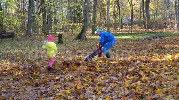 幸福的家庭男人和孩子一起玩秋花园的吹叶机视频的预览图