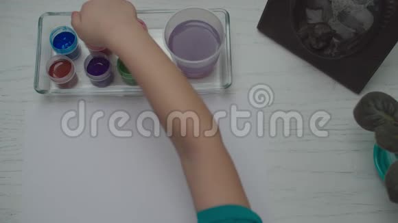孩子们用多种颜色的颜料在白纸上画画儿童手指画的俯视图视频的预览图