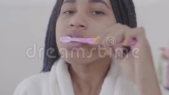 非洲裔美国年轻女性的特写照片她长着可怕的长发正在刷牙年轻漂亮的女孩在照顾自己视频的预览图