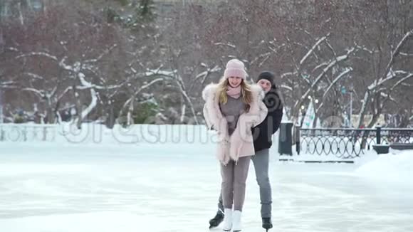 可爱的情侣在冰城溜冰场滑冰视频的预览图