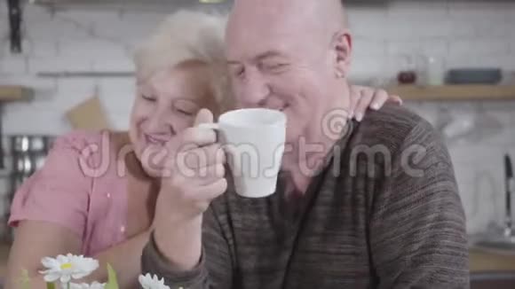 一对开朗成熟的夫妇坐在厨房里聊天快乐的高年级家庭在一起视频的预览图