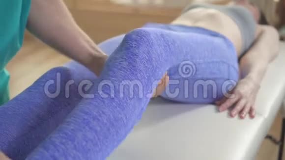 治疗师脊椎指压治疗受伤的膝关节运动员女性病人视频的预览图