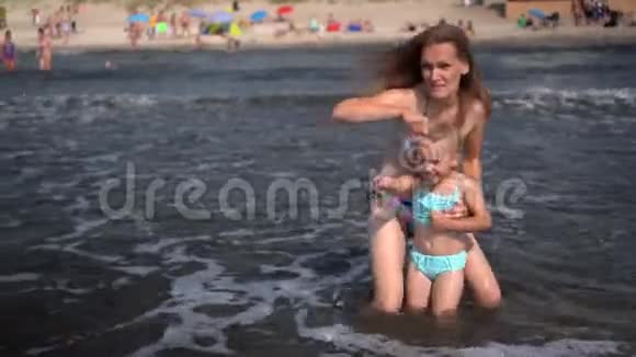 嬉戏的女人和女儿面对海浪情绪激动的女孩被泼水视频的预览图