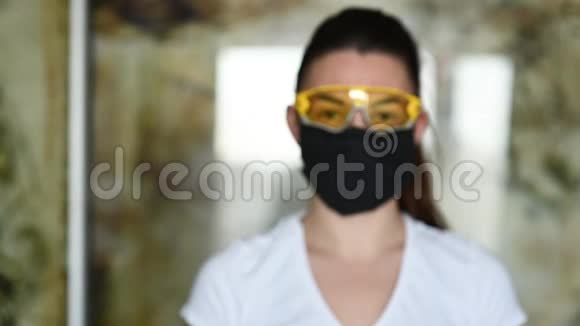戴防护面罩眼镜和手套的女孩喷洒防腐剂以防止感染视频的预览图