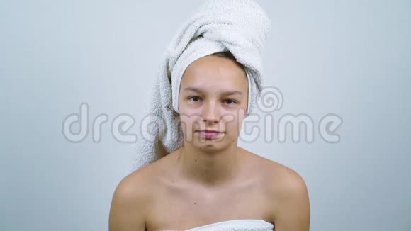 可爱的少年裹着毛巾检查她的脸上有痤疮视频的预览图