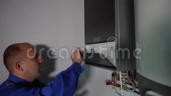 有平板电脑的工人在家中安装中央燃气供暖锅炉视频的预览图