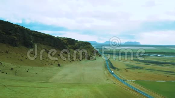 汽车旅行的无人视野冰岛的高山景观美丽的峡谷景观绿色平原的交通道路视频的预览图