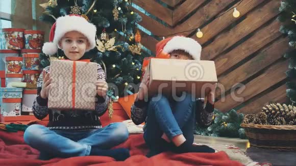 儿子和女儿为他们的父母准备了圣诞礼物并把它们展示给相机看上去为他们的一切感到骄傲视频的预览图