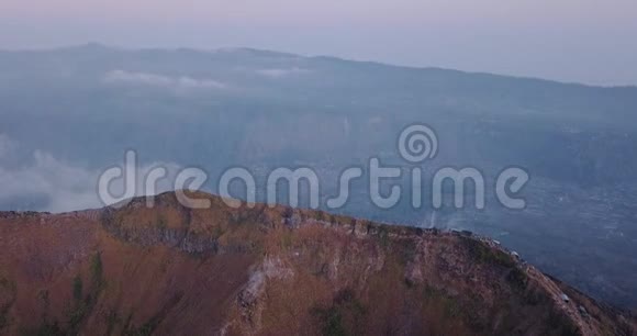 巴图尔火山峰在日出时被云层和景观包围上面有一群游客视频的预览图