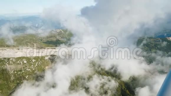 在飞机上飞过天空的云层鸟瞰高山之上悬崖之上视频的预览图