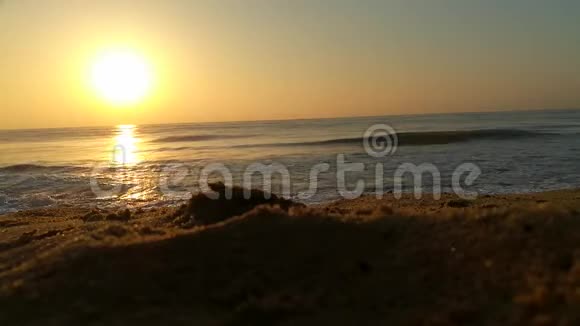 日落日出时太阳正落在地平线上越过海洋或海洋宁静的海洋海浪日出时的热带海滩背景视频的预览图