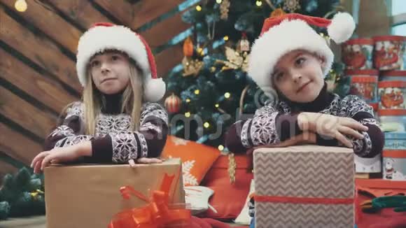 快乐的姐姐和哥哥们炫耀他们的新年礼物看着相机把头从一边移开视频的预览图