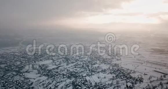 美丽的冬天雪花无人驾驶飞机在房屋上空盘旋美丽的日落视频的预览图