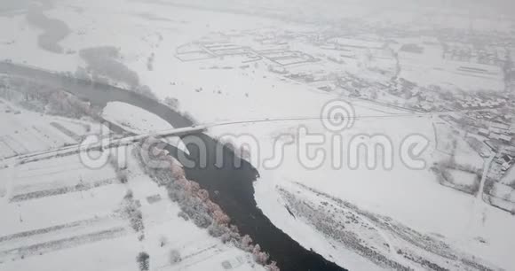 冬季河流飞行无人机桥上的河流降雪飞行视频的预览图