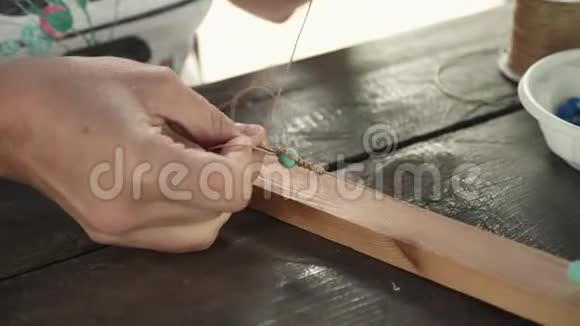将女性的手串在一根线上做成珠宝手镯视频的预览图