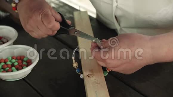 一个女人的手做一个手工制作的珠子手镯视频的预览图