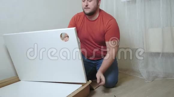 男人用螺丝刀从纸板上收集盒子视频的预览图