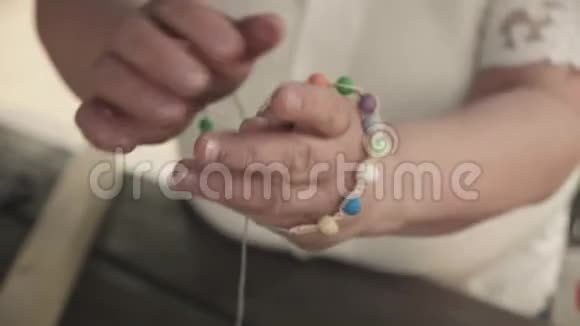 一只戴着由珠子制成的手工手镯的雌性手的特写视频的预览图