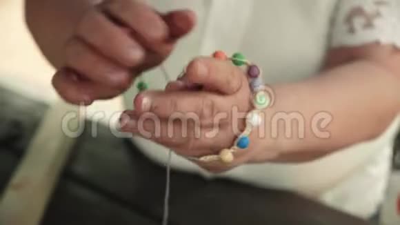 一只雌性手的特写手上戴着一由珠子制成的手工手镯视频的预览图