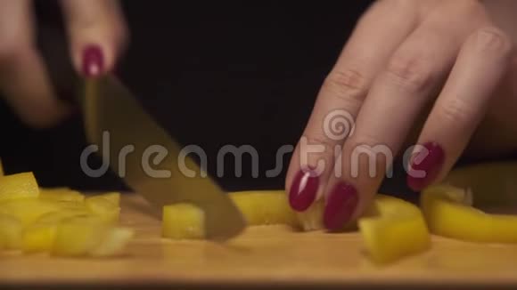 在现代厨房里女人用手在木板上切黄胡椒视频的预览图