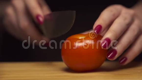 在现代厨房里女人用手在木板上切西红柿健康的饮食视频的预览图
