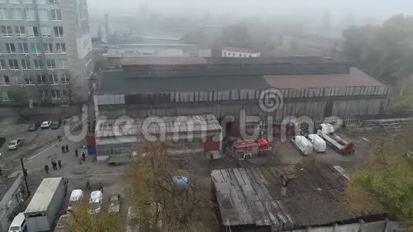 大火燃烧后的工业仓库中心大楼的空中景观从燃烧的屋顶冒出巨大的烟雾无人机射击视频的预览图