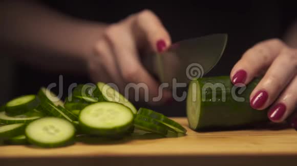 现代厨房里女人用手在木板上切黄瓜健康的饮食视频的预览图