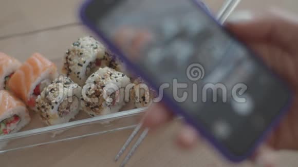 关闭手机屏幕拍照寿司和筷子女人吃日本菜用小玩意视频的预览图