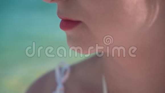 海滨女孩的肖像美丽的女孩嘴唇涂着红色的口红女孩嘴唇特写视频的预览图