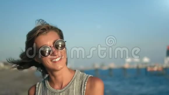 迷人的旅游女性在海景背景下放松地笑的特写镜头视频的预览图