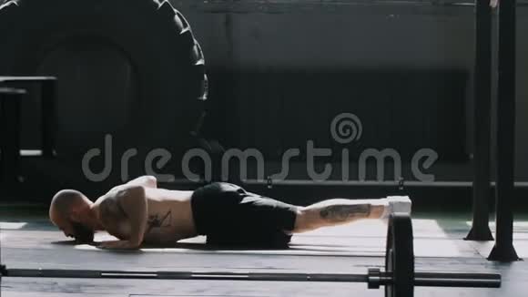 宽镜头的年轻白种人胡须肌肉运动员男子做俯卧撑运动在大型体育馆动机概念视频的预览图