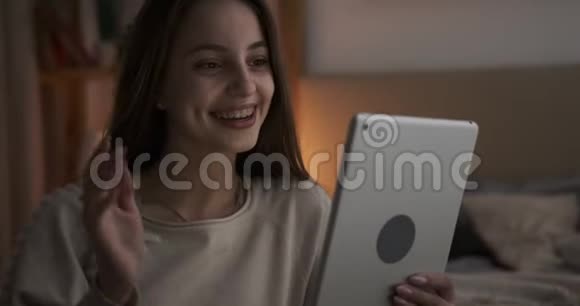 晚上使用数码平板电脑聊天的少女视频视频的预览图