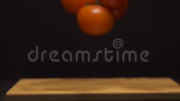 在现代化的厨房里女人手的特写把一枝西红柿放在木板上视频的预览图