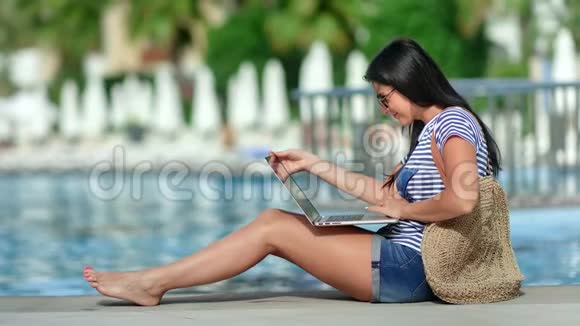 忙碌的自由职业者妇女微笑着在豪华度假酒店附近的笔记本电脑上工作视频的预览图