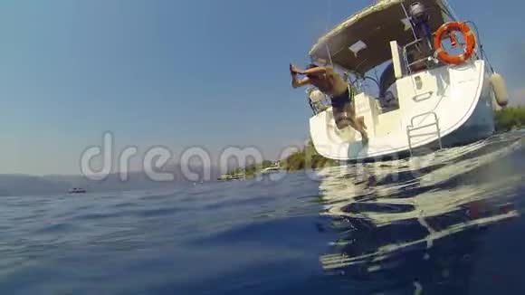 有趣的家伙从帆船的一侧潜入海里从水中射击视频的预览图