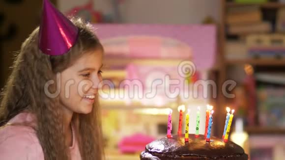 女孩在生日蛋糕上缓慢地吹蜡烛的肖像带着愿望接近孩子吹烛焰视频的预览图