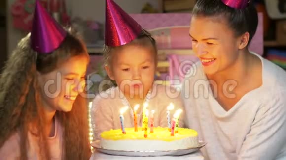 家庭生日派对快乐在家妈妈和孩子们一起慢慢地在生日蛋糕上吹蜡烛视频的预览图
