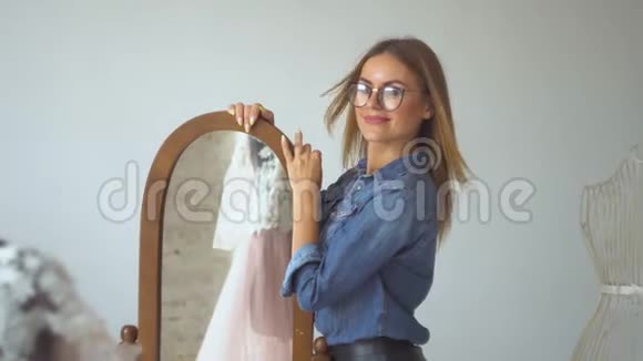 缝纫室里漂亮的女裁缝金发碧眼在模特身上检查一件衣服视频的预览图