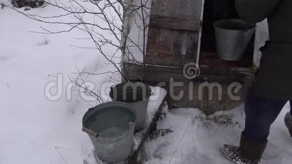 冬天下雪的时候人们往水桶里倒满了干净的水视频的预览图