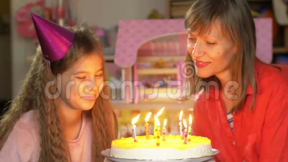 快乐的老妇人和她的小孙女吹生日蛋糕蜡烛幸福的家庭视频的预览图